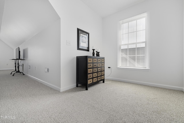 interior space with carpet floors, baseboards, and lofted ceiling