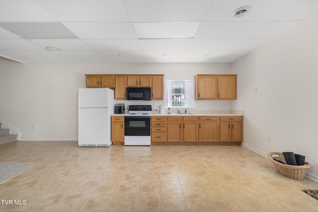 kitchen featuring electric range, black microwave, light countertops, freestanding refrigerator, and visible vents