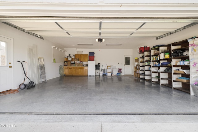 garage with a garage door opener and freestanding refrigerator