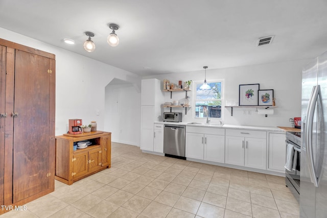 302 Wilson Ave, Johnson City, TN 37604 - kitchen with visible vents, arched walkways, open shelves, light countertops, and stainless steel appliances