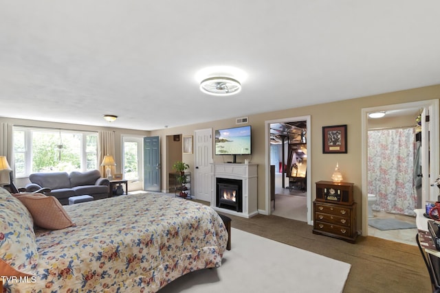 2004 Old Tusculum Rd, Greeneville, TN 37745 - bedroom featuring a glass covered fireplace, baseboards, ensuite bathroom, and carpet flooring