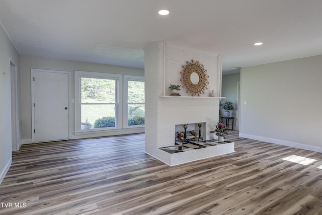 living room with recessed lighting, baseboards, wood finished floors, and a fireplace