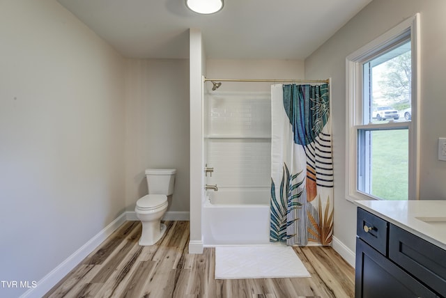 bathroom featuring wood finished floors, vanity, baseboards, toilet, and shower / bathtub combination with curtain