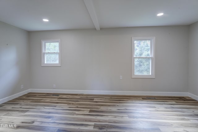 empty room with baseboards, recessed lighting, wood finished floors, and beamed ceiling