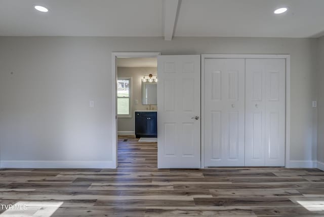 unfurnished bedroom with recessed lighting, baseboards, and wood finished floors