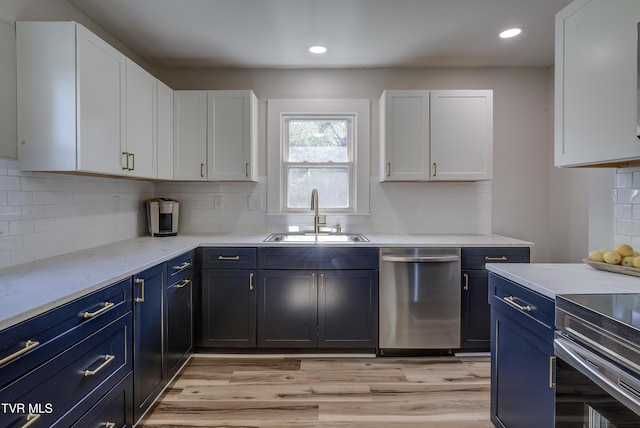 kitchen with a sink, white cabinetry, dishwasher, and blue cabinetry