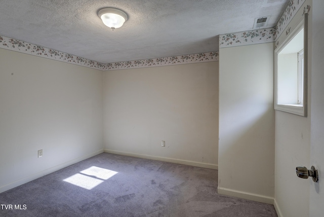 carpeted empty room with a textured ceiling, visible vents, and baseboards