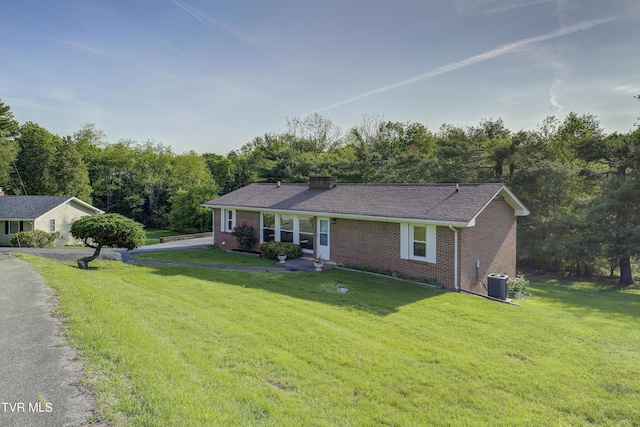 ranch-style home with central air condition unit, brick siding, and a front lawn