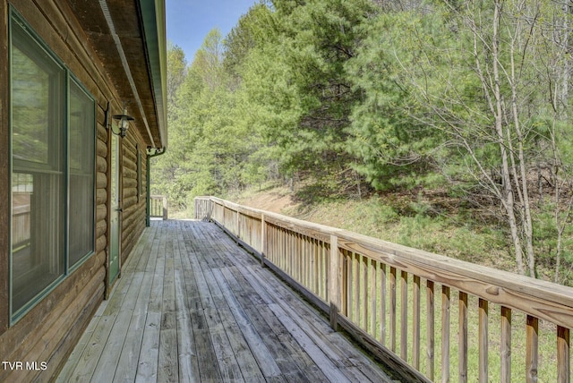 wooden terrace featuring a wooded view