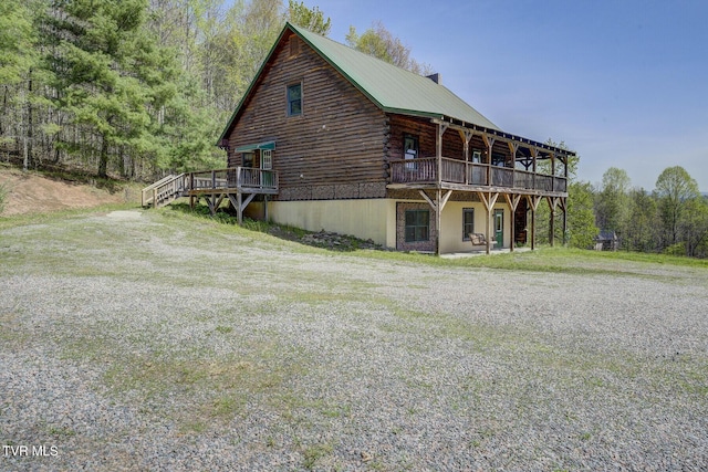 exterior space with log siding and a wooden deck