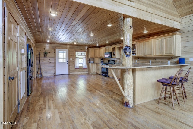 kitchen featuring wood ceiling, a breakfast bar, black appliances, and light wood finished floors