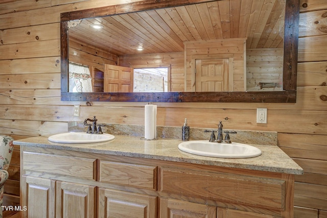 bathroom with a sink, wood walls, and double vanity