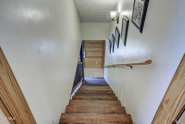 staircase featuring a textured ceiling
