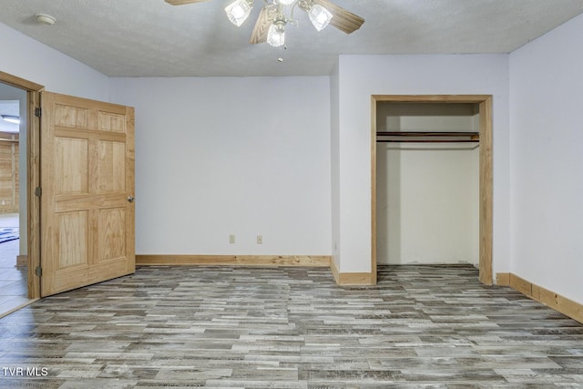 unfurnished bedroom with baseboards, ceiling fan, wood finished floors, and a closet
