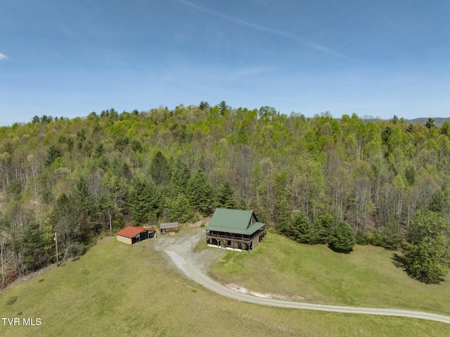 birds eye view of property featuring a view of trees