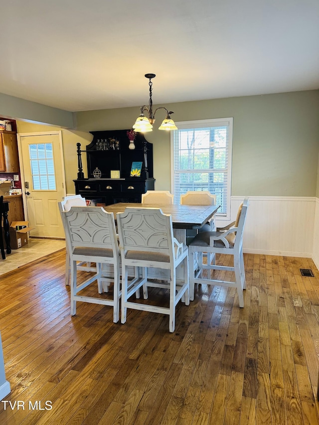 84 Deerview Ln, Lebanon, VA 24266 - dining space featuring wood-type flooring, a chandelier, a wainscoted wall, and visible vents