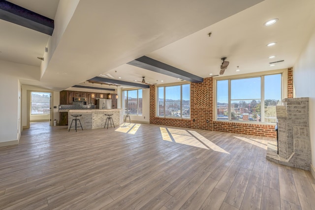 200 E Main St Unit 5, Johnson City, TN 37604 - unfurnished living room with baseboards, light wood finished floors, beam ceiling, and a wealth of natural light