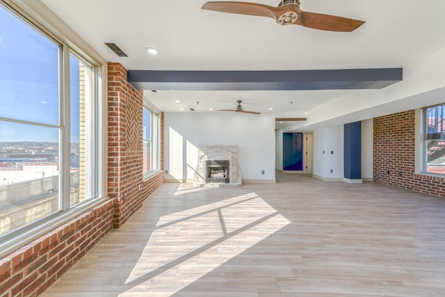 200 E Main St Unit 5, Johnson City, TN 37604 - unfurnished living room featuring a healthy amount of sunlight, a high end fireplace, a ceiling fan, and brick wall