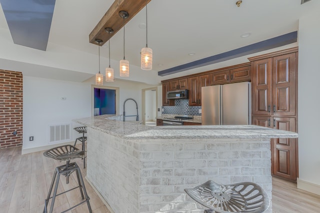 200 E Main St Unit 5, Johnson City, TN 37604 - kitchen featuring visible vents, a spacious island, light wood-type flooring, a sink, and appliances with stainless steel finishes
