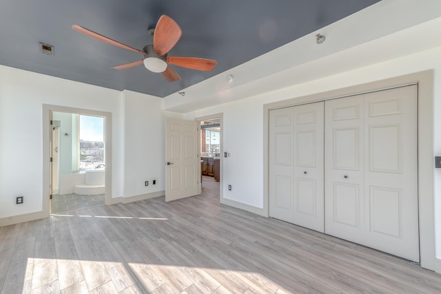 200 E Main St Unit 5, Johnson City, TN 37604 - unfurnished bedroom featuring baseboards, light wood-style flooring, a closet, and multiple windows