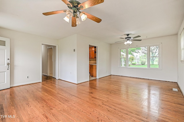 unfurnished living room featuring visible vents, a ceiling fan, light wood-style floors, and baseboards