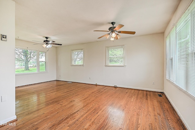 unfurnished room with ceiling fan, visible vents, baseboards, and light wood-style floors