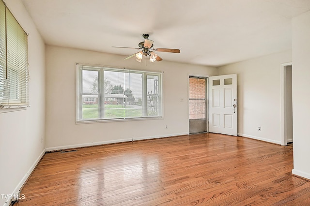 spare room with visible vents, a ceiling fan, baseboards, and wood finished floors