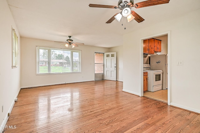 unfurnished living room featuring a ceiling fan, baseboards, and light wood-style flooring