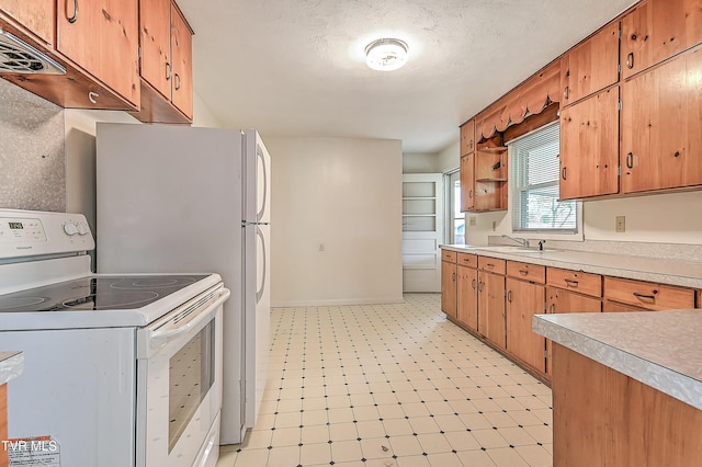 kitchen featuring white electric range, light countertops, light floors, and brown cabinets