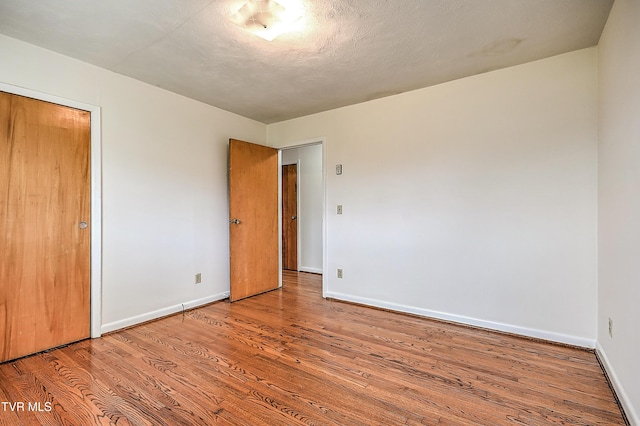 unfurnished bedroom featuring baseboards and wood finished floors