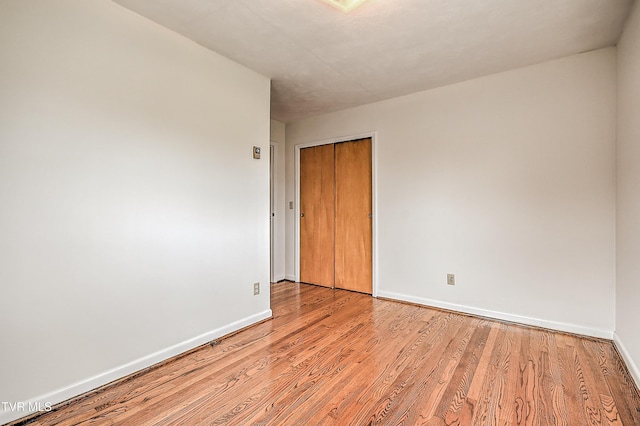 empty room featuring baseboards and light wood-style flooring