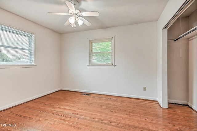 unfurnished bedroom with multiple windows, a closet, light wood-type flooring, and visible vents