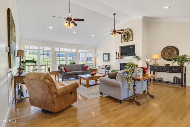 963 Beaver Creek Rd, Bluff City, TN 37618 - living area with crown molding, light wood-style floors, ceiling fan, a tile fireplace, and vaulted ceiling