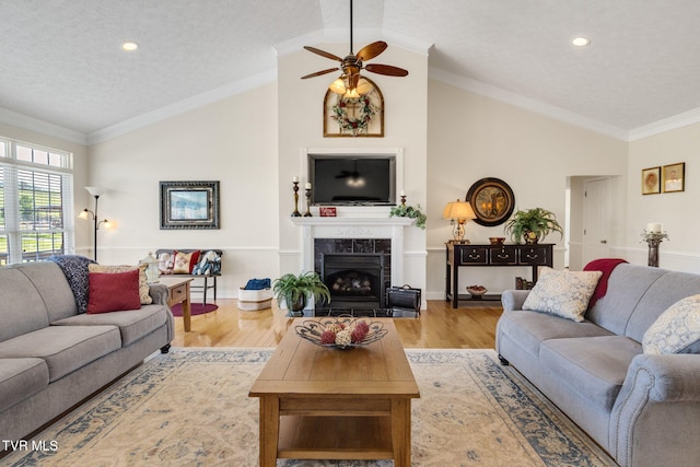 963 Beaver Creek Rd, Bluff City, TN 37618 - living area with ceiling fan, a textured ceiling, a tiled fireplace, wood finished floors, and lofted ceiling