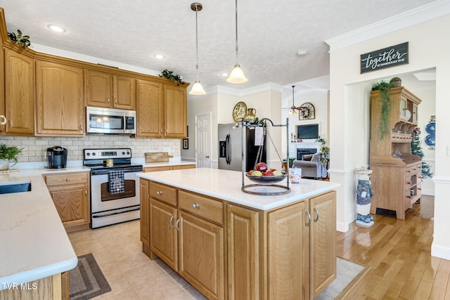 963 Beaver Creek Rd, Bluff City, TN 37618 - kitchen featuring decorative backsplash, ornamental molding, a center island, light countertops, and stainless steel appliances