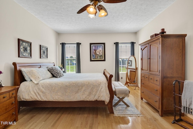 963 Beaver Creek Rd, Bluff City, TN 37618 - bedroom with light wood-style flooring, a textured ceiling, and a ceiling fan