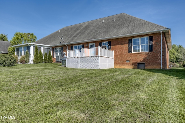 rear view of house with a wooden deck, brick siding, a shingled roof, crawl space, and a yard