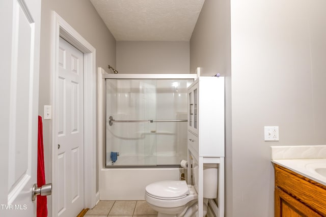 bathroom with a textured ceiling, tile patterned flooring, vanity, combined bath / shower with glass door, and toilet
