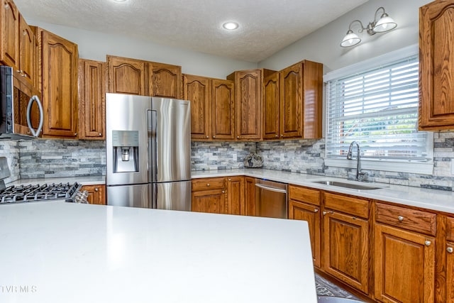 kitchen featuring a sink, light countertops, decorative backsplash, and stainless steel appliances