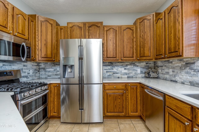 kitchen with light countertops, appliances with stainless steel finishes, and decorative backsplash