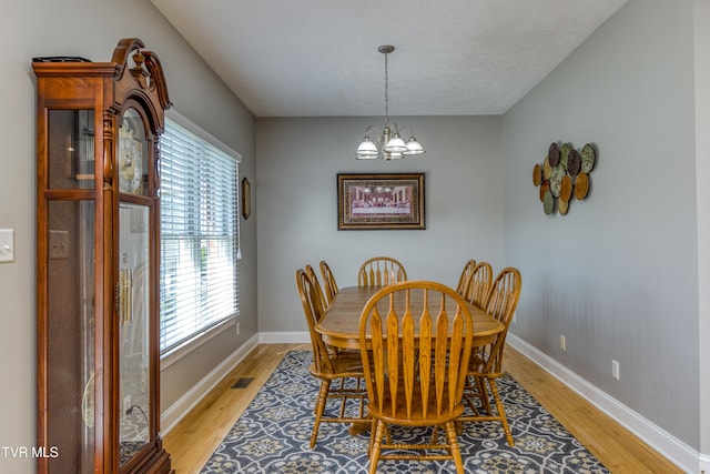 dining space featuring an inviting chandelier, light wood-type flooring, and a healthy amount of sunlight