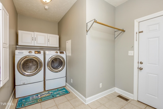 clothes washing area with baseboards, visible vents, washing machine and dryer, and light tile patterned floors