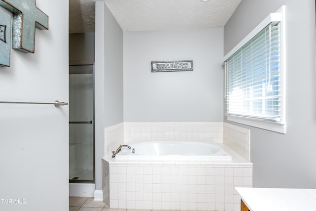 full bath with vanity, a textured ceiling, a bath, tile patterned floors, and a stall shower