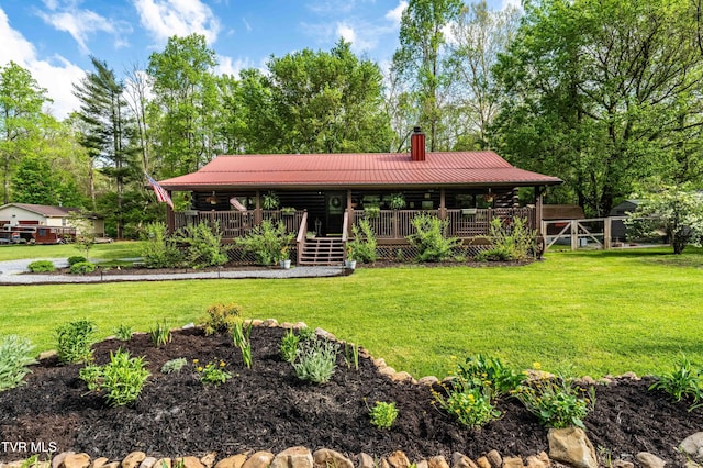 view of front of property featuring log siding, a chimney, metal roof, and a front yard