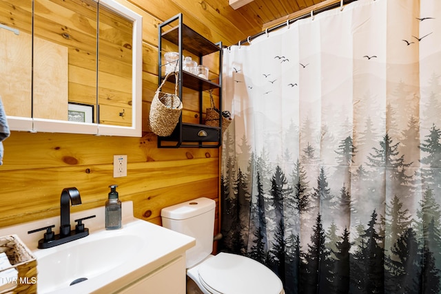 bathroom featuring toilet, a shower with curtain, wood walls, and vanity