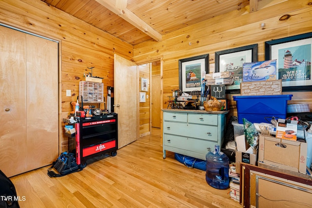 interior space with a closet, wood finished floors, beamed ceiling, wooden walls, and wooden ceiling