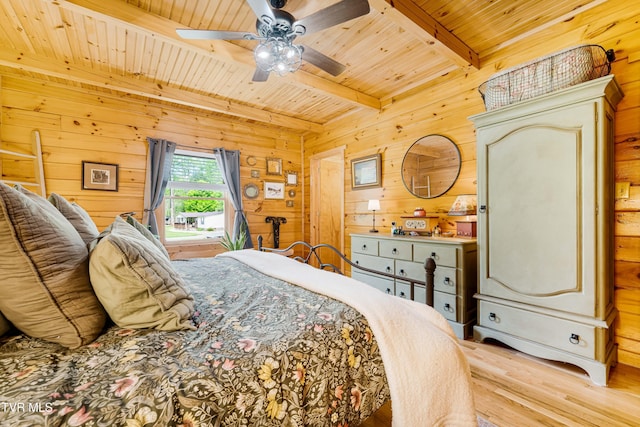 bedroom featuring wood finished floors, beamed ceiling, wooden walls, wooden ceiling, and a ceiling fan