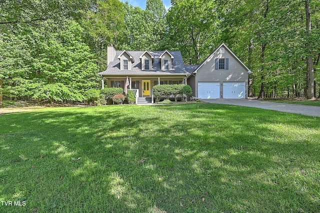 new england style home with a front lawn, a chimney, covered porch, driveway, and a wooded view