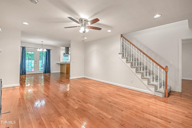 unfurnished living room with stairway, baseboards, ceiling fan, and light wood finished floors