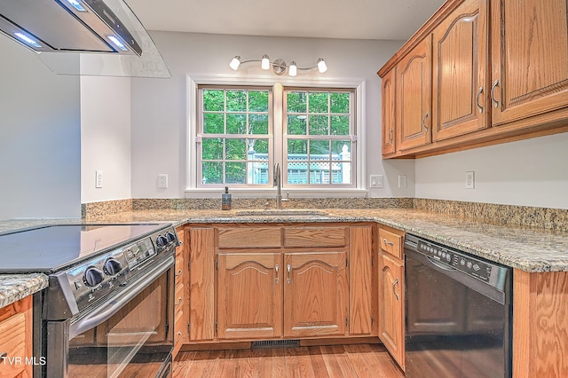 kitchen with visible vents, a sink, ventilation hood, black appliances, and light wood finished floors